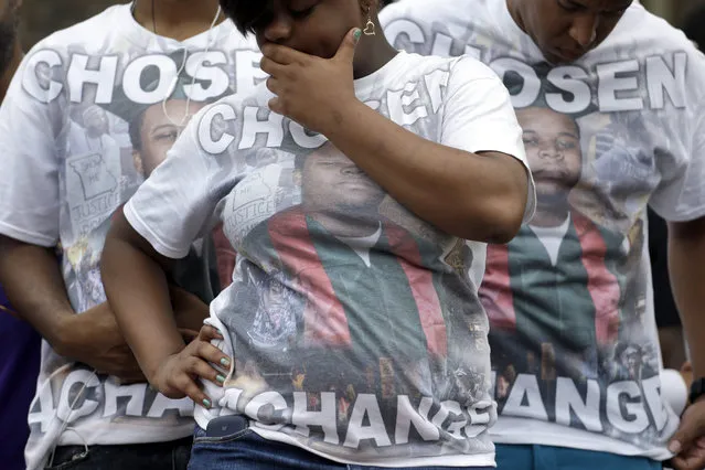 Supporters of Michael Brown wear shirts with his picture and the message “Chosen 4 ChangeÆ as they take part in a remembrance ceremony at the spot where he was shot and killed Sunday, August 9, 2015, in Ferguson, Mo. Sunday marks one year since Michael Brown was shot and killed by Ferguson police officer Darren Wilson. (Photo by Jeff Roberson/AP Photo)