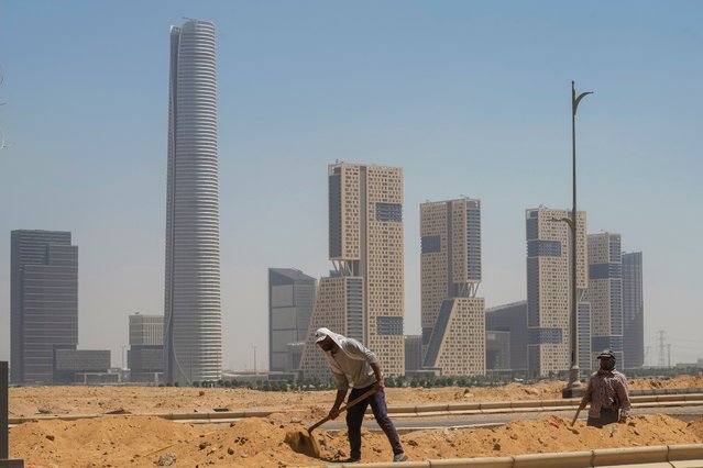 Egyptian workers dig in a pavement at the New Administrative Capital (NAC), just outside Cairo, Egypt, Wednesday, August 14, 2024. (Photo by Amr Nabil/AP Photo)