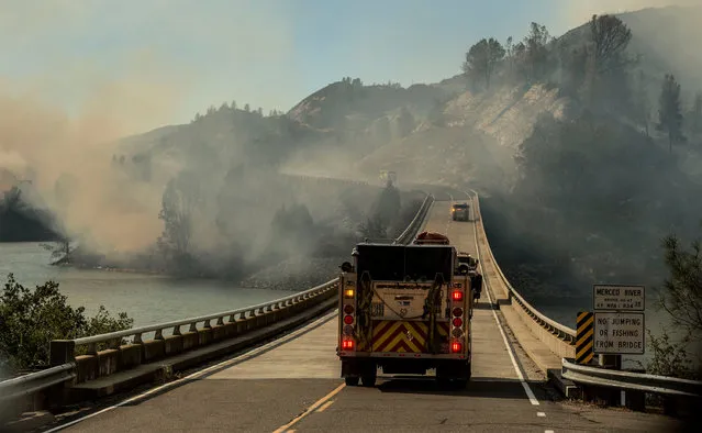 A firetruck drives across the Merced River at the Bagby bridge after authorities ordered evacuations due to the Detwiler fire in Mariposa, California, U.S. July 18, 2017. (Photo by Al Golub/Reuters)