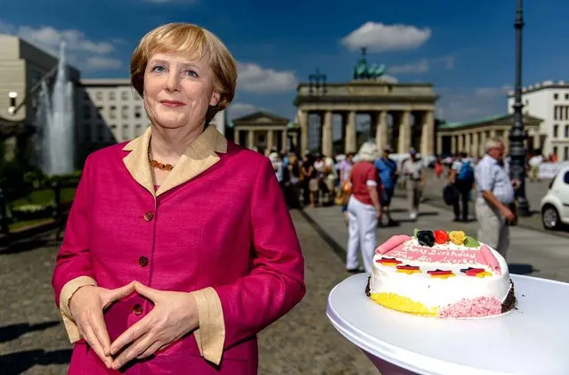 A wax likeness of German Chancellor Angela Merkel is pictured in front of the Brandenburg Gate in Berlin on July 16, 2014, on the occassion of Merkel's 60th birthday on July 17. (Photo by Clemens Bilan/AFP Photo)