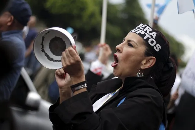 A woman yells as she hits a pan during a protest to demand the resignation of Guatemala's President Otto Perez Molina in Guatemala City, August 15, 2015. Demonstrators are demanding the resignation of Perez Molina for the corruption scandals of politicians close to his government and his administration. (Photo by Josue Decavele/Reuters)