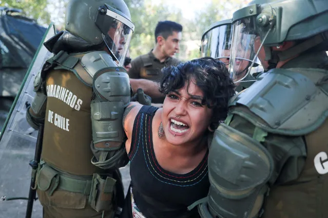 A demonstrator is detained by members of the security forces during a protest against Chile's government in Santiago, Chile on December 17, 2019. (Photo by Ivan Alvarado/Reuters)