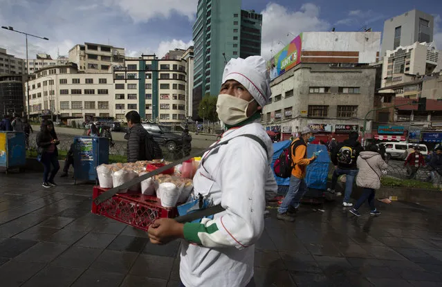 A fried chicken vendor wears a face mask as a preventative measure against the spread of the new coronavirus, in La Paz, Bolivia, Wedensday, March 18, 2020. Authorities have decreed a quarantine from 5pm to 5am in an attempt to stop the spread of the new coronavirus. The vast majority of people recover from the COVID-19 disease. (Photo by Juan Karita/AP Photo)