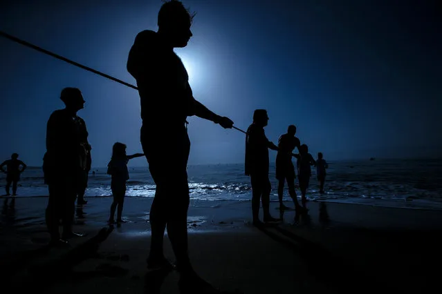 Fishermen attend the traditional fishing art “tirada del copo”, nowadays banned, during an event held to evoke the ancient trade of fishing in Los Boliches beach in Fuegirola, Spain, 15 August 2017. This kind of fishing was banned back in the 60s due to secure the fishing resource. (Photo by Jorge Zapata/EPA)