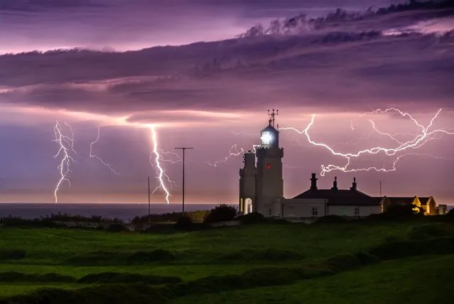 Lightning illuminates the English Channel at St Catherine's Lighthouse on the Isle of Wight on May 15, 2022. (Photo by Jamie Russell/Bournemouth News)