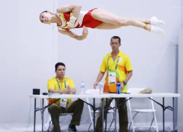 An artistic gymnastic athlete from China's women team practices as officials looks on during a training session for the Rio 2016 Olympic Games at the Athletes' Park near the Olympic Village in Rio de Janeiro, Brazil, 02 August 2016. (Photo by How Hwee Young/EPA)