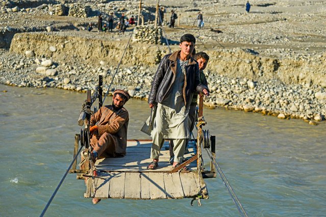 Afghans ride a zipline to cross the Kokcha river at Yaftal Sufla district in Badakhshan province on January 16, 2025. (Photo by Omer Abrar/AFP Photo)