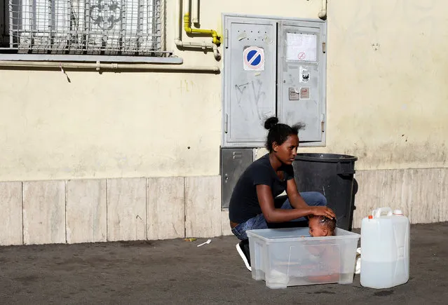A migrant washes her baby at a makeshift camp in Via Cupa (Gloomy Street) in downtown Rome, Italy, August 1, 2016. (Photo by Max Rossi/Reuters)