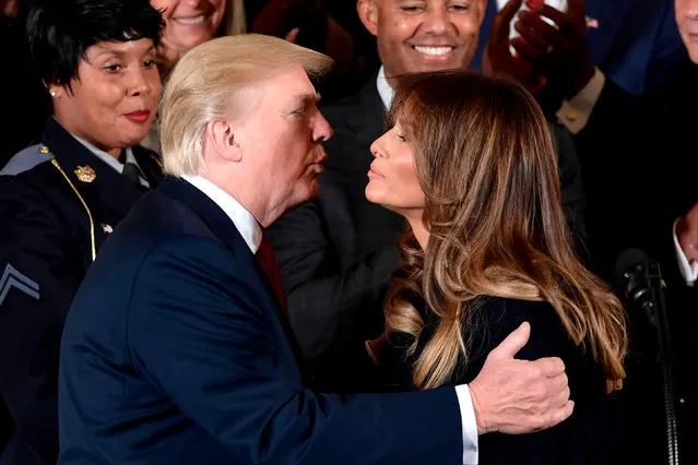 US President Donald Trump kisses US First Lady Melania Trump before delivering remarks on combatting drug demand and the opioid crisis on October 26, 2017 in the East Room of the White House in Washington, DC. US President Donald Trump on October 26, 2017 declared the opioid crisis a “nationwide public health emergency”, stepping up the fight against an epidemic that kills more than 100 Americans every day, officials said. Trump is to make the announcement at an event at the White House later Thursday attended by former addicts and parents of victims, the senior administration officials said. (Photo by Brendan Smialowski/AFP Photo)