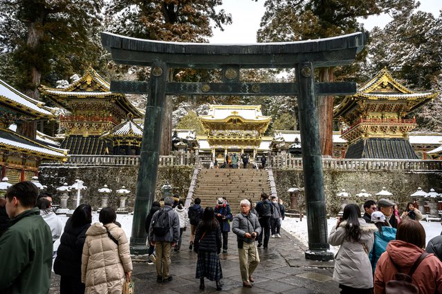 This photograph taken on February 10, 2025 shows tourists visiting the snow covered Toshogu shrine, the final resting place of Ieyasu, the first Tokugawa shogun, a famous tourism spot and UNESCO World Heritage Site in Nikko city of Tochigi Prefecture. (Photo by Mladen Antonov/AFP Photo)
