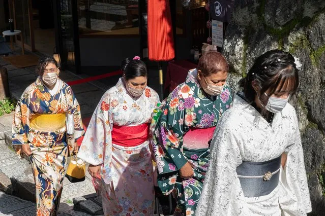 Visitors wearing kimonos walk up a steps along a street in Kyoto on October 11, 2022. (Photo by Fred Mery/AFP Photo)