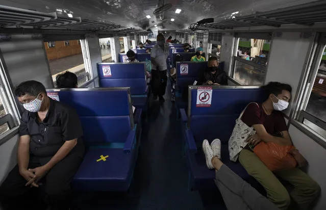 Passengers on a train with staggered seating wear face masks to curb the spread of the coronavirus at the Hua Lamphong Railway Station in Bangkok, Thailand, Tuesday, June 9, 2020. The Thai government continues to ease restrictions related to running business in capital Bangkok that were imposed weeks ago to combat the spread of COVID-19. (Photo by Sakchai Lalit/AP Photo)