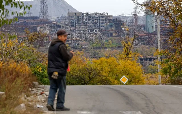 A man walks along a road with Azovstal steel mill in the background, destroyed in the course of Russia-Ukraine conflict, in Mariupol, Russian-controlled Ukraine on October 29, 2022. (Photo by Alexander Ermochenko/Reuters)