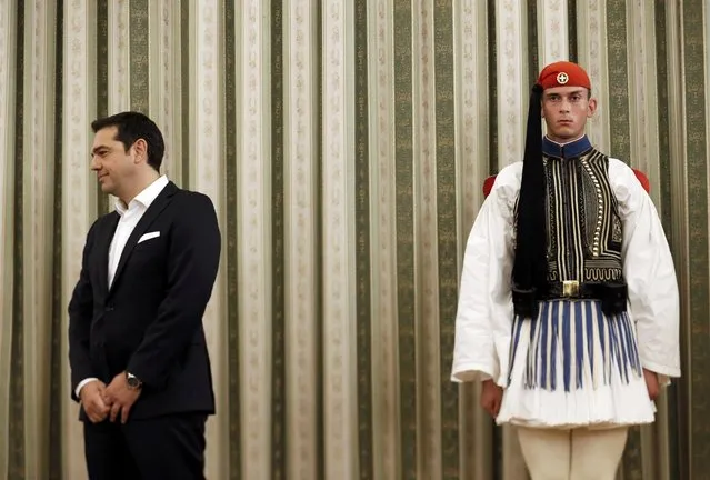 Leftist Syriza leader and winner of Greek general election Alexis Tsipras stands next to a presidential guardsman during a ceremony in which he was sworn in as prime minister by Greek President Prokopis Pavlopoulos at the presidential palace in Athens, September 21, 2015. (Photo by Alkis Konstantinidis/Reuters)