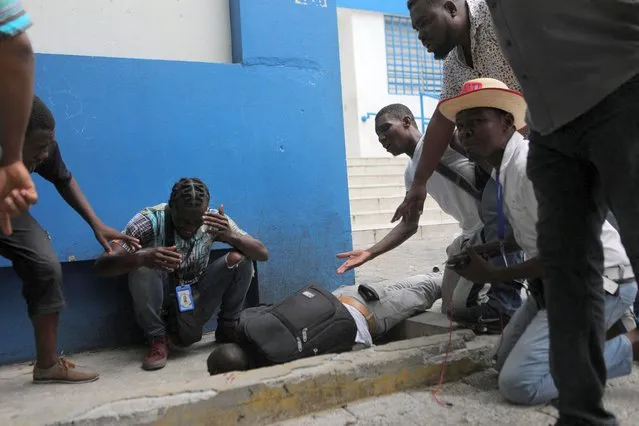 Demonstrators and journalists react next to the body of journalist Romelson Vilcin, who was shot dead during a protest, outside a police station in Port-au-Prince, Haiti on October 30, 2022. (Photo by Ralph Tedy Erol/Reuters)