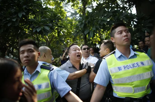 An anti-Occupy Central protester (C) shouts to pro-democracy protesters as he is dragged away by police officers at the main protest site in Admiralty in Hong Kong, October 13, 2014. (Photo by Carlos Barria/Reuters)