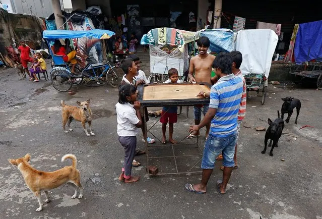 People play carrom along a roadside at a slum area in Kolkata, India, August 22, 2016. (Photo by Rupak De Chowdhuri/Reuters)