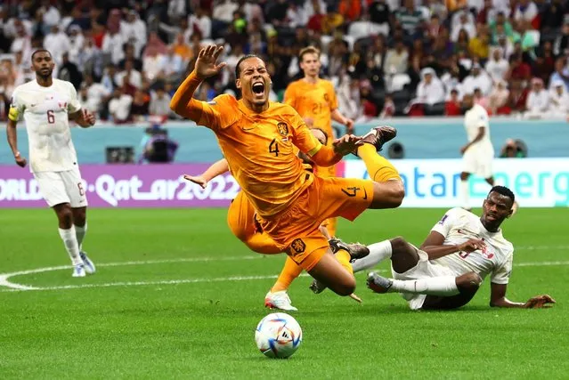 Netherlands' defender #04 Virgil van Dijk is tackled during the Qatar 2022 World Cup Group A football match between the Netherlands and Qatar at the Al-Bayt Stadium in Al Khor, north of Doha on November 29, 2022. (Photo by Bernadett Szabo/Reuters)