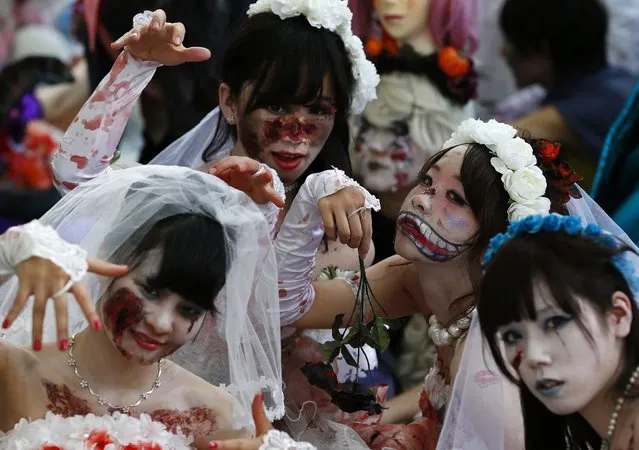Participants in costumes pose for pictures after a Halloween parade in Kawasaki, south of Tokyo, October 26, 2014. (Photo by Yuya Shino/Reuters)