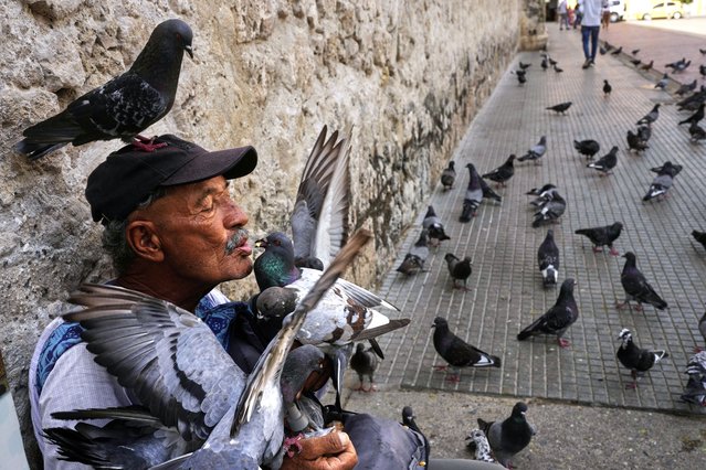 Jean Paul Correa Vasco feeds pigeons outside the Cathedral in Cartagena, Colombia, Thursday, May 8, 2025. (Photo by Rodrigo Abd/AP Photo)