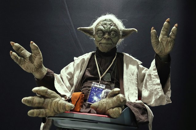 A Star Wars fan dressed as Yoda tries to look airborne during a fan convention called the Star Wars Celebration Japan in Chiba, near Tokyo, Friday, April 18, 2025. (Photo by Hiro Komae/AP Photo)