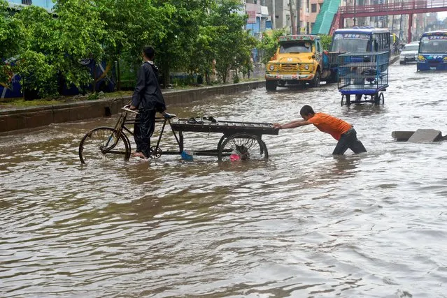 Vehicles try driving and citizens are walking through the water logging Dhaka streets in Bangladesh, on July 22, 2020. Heavy monsoon downpour caused extreme water logging in most areas of Dhaka city, Bangladesh. Roads were submerged making travel slow and dangerous. (Photo by Mamunur Rashid/NurPhoto via Getty Images)