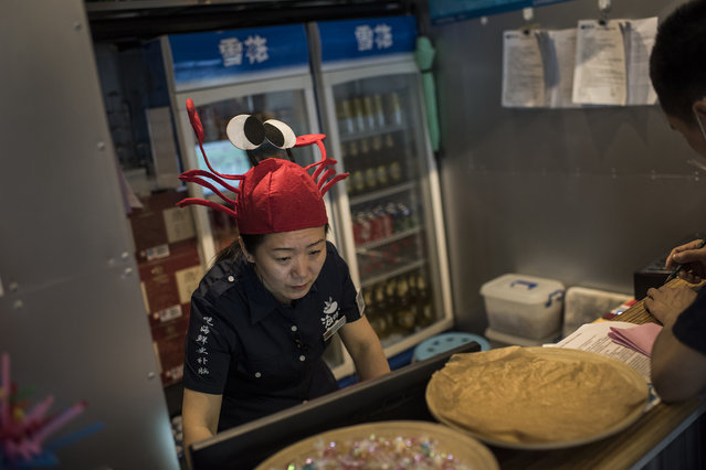 An employee, adorned with a lobster hat, works at an American themed seafood restaurant in Beijing on May 26, 2016. Statistics show that rural migration into the cities may be plateauing in China and that the average age of rural employees is rising. Migrant workers have been streaming into China's urban centers for years as the economy of the country has shifted from rural to urban. According to an annual survey by the National Bureau of Statistics, there were over 277 million rural laborers working in China's cities in 2015. (Photo by Michael Robinson Chavez/The Washington Post)