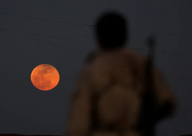 A fighter from Free Syrian Army is seen watching a full moon rises in Daraa, Syria on January 31, 2018. (Photo by Alaa al-Faqir/Reuters)