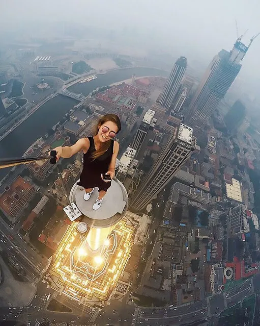 An astonishing set of snaps of a thrill-seeker's sky-high catwalk show on the edge of some of the world's tallest buildings has turned her into a social media sensation. Daredevil Angelina Nikolau, 23, from Russia, has spent weeks travelling around China and Hong Kong posing for jaw-dropping skyscraper selfies hundreds of feet above the ground. Her vertigo inducing results – uploaded to Instagram – have made her an instant star on the internet. Angelina is described by Russian media as “self-taught photographer, adventurer and roofer from Moscow”. Roofing – also known as rooftopping – is where people get as close as possible to the edge of a skyscraper's highest point to take selfies. (Photo by Kirill Oreshkin/CEN)