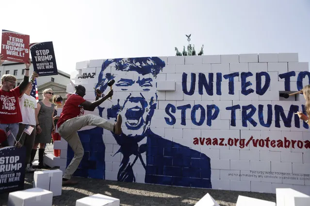 Protestors are tearing down a so called “Trump's wall of hate” as part of a demonstration against Republican presidential candidate Donald Trump in front of the Brandenburg Gate at the Pariser Platz in Berlin, Germany, Friday, September 23, 2016. (Photo by Markus Schreiber/AP Photo)