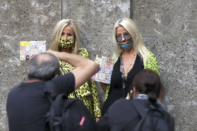 Two guests pose for photographers prior to the Dolce & Gabbana 2021 women's spring-summer ready-to-wear collection during the Milan's fashion week in Milan, Italy, Wednesday, September 23, 2020. (Photo by Luca Bruno/AP Photo)