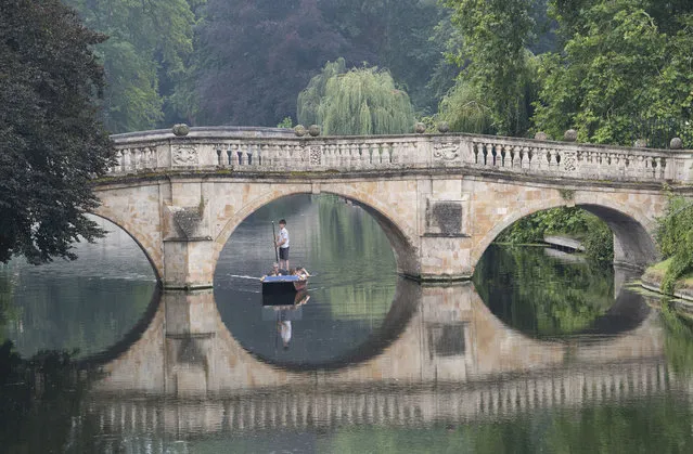People enjoy the hot weather as they take a punt trip along the River Cam in Cambridge, England Tuesday August 11, 2020. After days of scorching temperatures, large swathes of the UK could be hit by severe thunderstorms this week. (Photo by Joe Giddens/PA Wire via AP Photo)