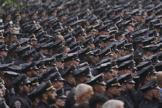 New York Police officers stand at attention as the hearse carrying the casket of officer Didarul Islam passes after his funeral, Thursday, July 31, 2025, in New York. (Photo by Angelina Katsanis/AP Photo)