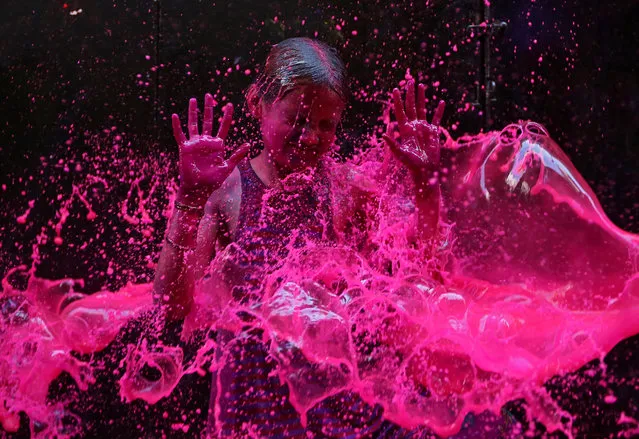 A girl reacts as she is splashed with coloured water during Holi celebrations in Chennai, India on March 2, 2018. (Photo by P. Ravikumar/Reuters)