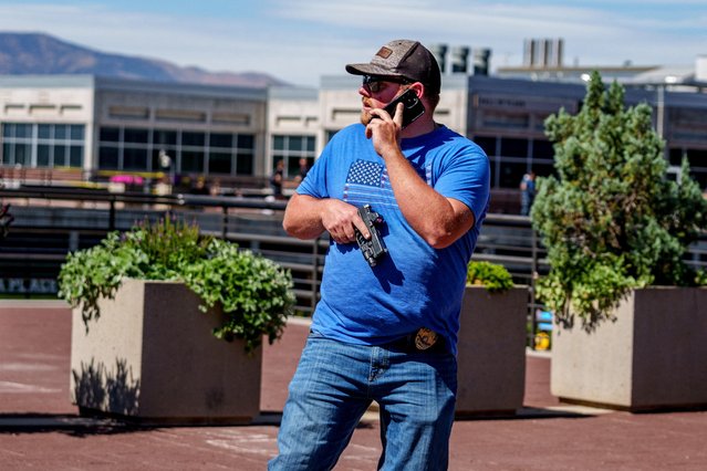 A law enforcement officer holds a handgun after U.S. right-wing activist and commentator Charlie Kirk was shot at a Utah Valley University speaking event in Orem, Utah, U.S. on September 10, 2025. (Photo by Trent Nelson/The Salt Lake Tribune via Reuters)