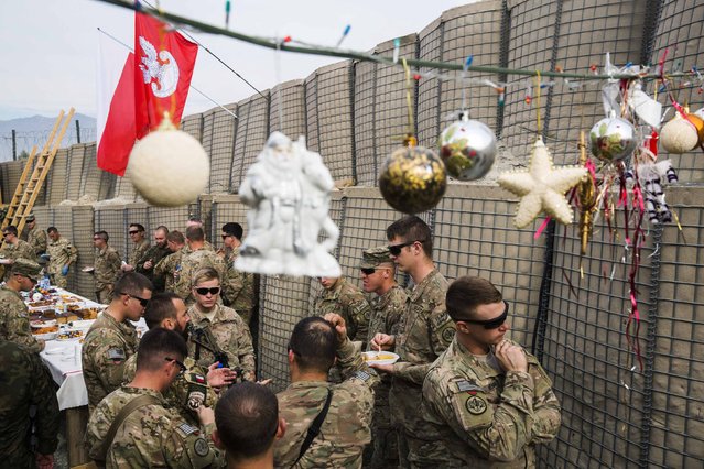 U.S. soldier from the 3rd Cavalry Regiment take part in a Christmas Eve celebration with soldiers from the Polish army's 21st Mountain Brigade on forward operating base Gamberi in the Laghman province of Afghanistan December 24, 2014. (Photo by Lucas Jackson/Reuters)