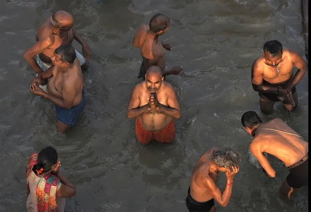 Devotees take holy dips and pray in the river Saryu on the occasion of Ramnavi festival, celebrated as the birthday of Hindu God Rama, in Ayodhya, India, Thursday, March 30, 2023. Ayodhya is also the birthplace of lord Rama. (Photo by Manish Swarup/AP Photo)