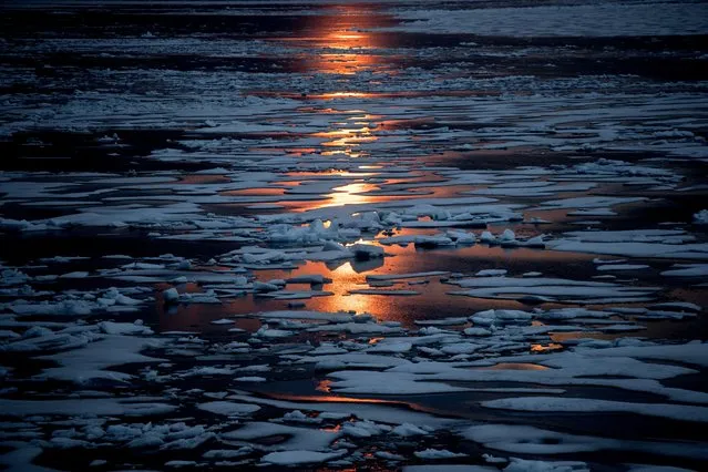 The midnight sun shines across sea ice along the Northwest Passage in the Canadian Arctic Archipelago, July 23, 2017. A new study Wednesday, March 15, 2023, says the thickness of sea ice dropped sharply in two sudden events about 15 years ago. (Photo by David Goldman/AP Photo)