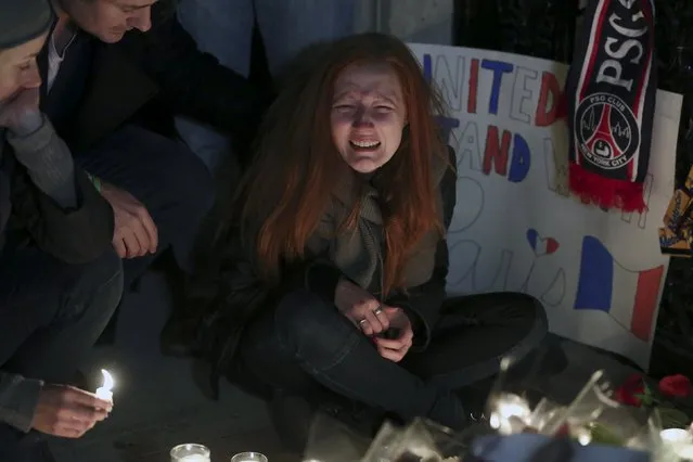 Polina Volkova, a friend of Eagles Of Death Metal Nick Alexander who died in attacks in Paris, cries as she sits near a makeshift vigil outside the consulate of France in the Manhattan borough of New York November 14, 2015. (Photo by Carlo Allegri/Reuters)
