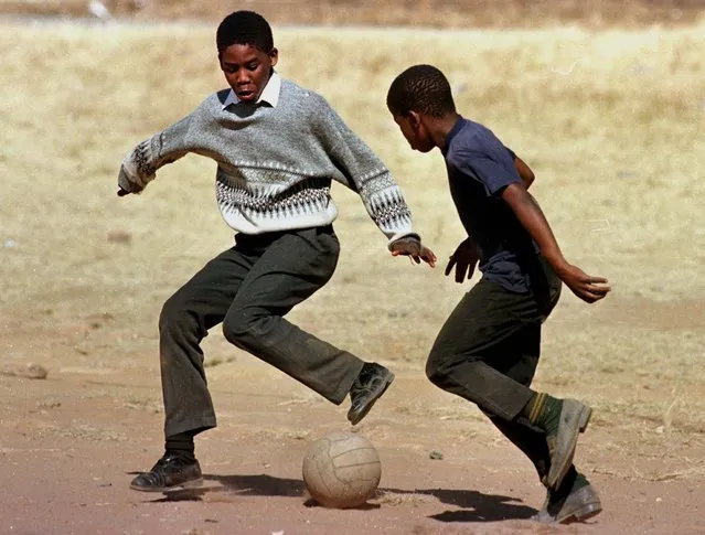 Two school children dreaming of stardom play soccer with an old weathered ball in the yard of a Soweto school June 12, as South Africans await their team's first-ever match in the World Cup finals. (Photo by Juda Ngwenya/Reuters)