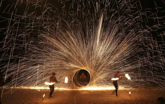 Filipino fire dancers perform for the last time a day before the government implements the temporary closure of the country's most famous beach resort island of Boracay, in central Aklan province, Philippines, on Wednesday, April 25, 2018. Tourists are spending their final hours on Boracay, enjoying the Philippine island's famed white-sand beaches before it closes for up to six months to recover from overcrowding and development. (Photo by Aaron Favila/AP Photo)