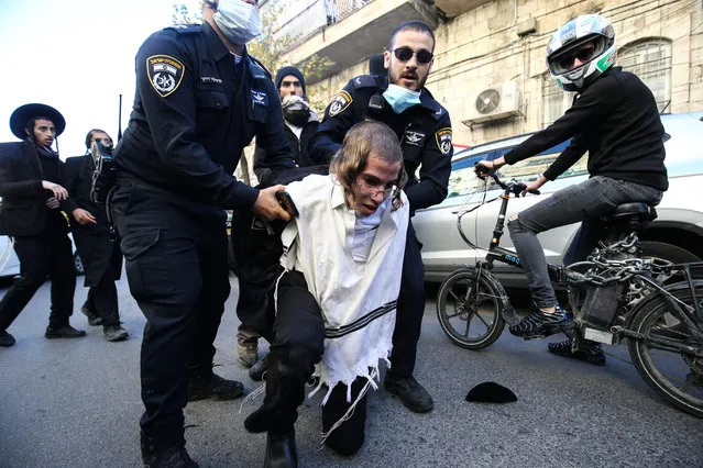 Israeli security forces take a protester into custody as anti-zionist Orthodox Jewish religious group members, known as Neturei Karta, gather to stage a protest against zionism and Israel at Mea Shearim neighborhood in Jerusalem on December 20, 2020. (Photo by Mostafa Alkharouf/Anadolu Agency via Getty Images)