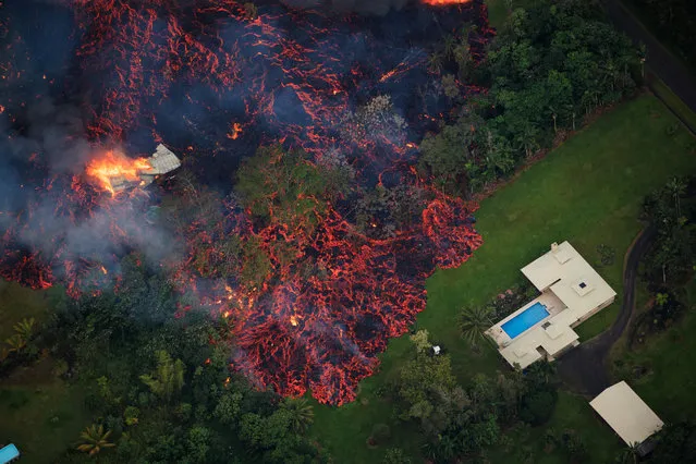 Lava from a robust fissure eruption on Kilauea's east rift zone consumes a home, then threatens another, near Pahoa, Hawaii, USA, 06 May 2018. The total number of homes lost within the Leilani Estates subdivision thus far is 21, and geologists from the Hawaii Volcanoes Observatory do not expect the eruption to cease any time soon. A local state of emergency has been declared after Mount Kilauea erupted near residential areas, forcing mandatory evacuation of about 1,700 citizens from their nearby homes. The crater's floor collapsed on 01 May and is since then continuing to erode its walls and generating huge explosions of ashes. Several earthquakes have been recorded in the area where the volcanic eruptions continue, including a 6.9 magnitue earthquake which struck the area on 04 May. (Photo by Bruce Omori/EPA/EFE/Paradise Helicopters)