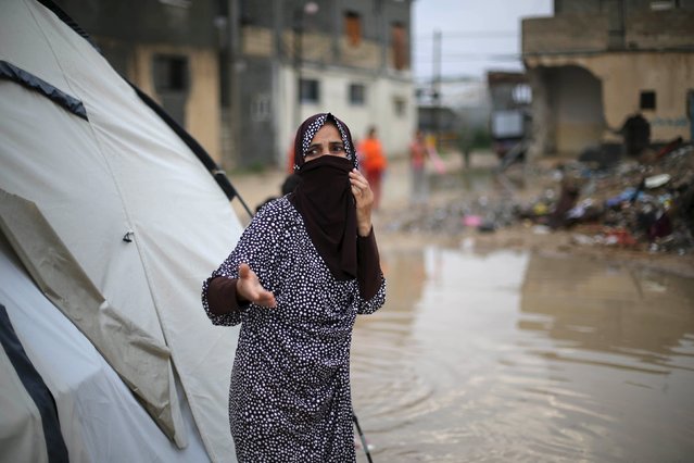 A Palestinian woman, whose house was destroyed by what witnesses said was Israeli shelling during the 50-day war in the summer of 2014, reacts after rainwater flooded her makeshift shelter in Khan Younis in the southern Gaza Strip October 7, 2015. (Photo by Ibraheem Abu Mustafa/Reuters)