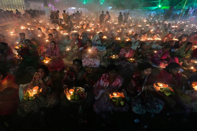 Devotees pray with lamps during a ritual of Rakher Upobash, a Hindu religious festival that involves daylong fast and overnight prayer seeking spiritual purification, honoring Hindu saint Loknath Brahmachari at a temple, in Chakla, North 24 Parganas, West Bengal, India, Saturday, November 15, 2025. (Photo by Bikas Das/AP Photo)
