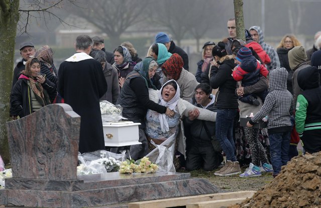 The mother of Maria Francesca, who died of sudden infant death syndrome, cries in front of the coffin of her baby during the funeral in Wissous, outside Paris, France, Monday, January 5, 2015. Wissous offered a gravesite for the baby after the mayor of Champlan, where the child and mother lived, reportedly refused a burial plot. (Photo by Christophe Ena/AP Photo)