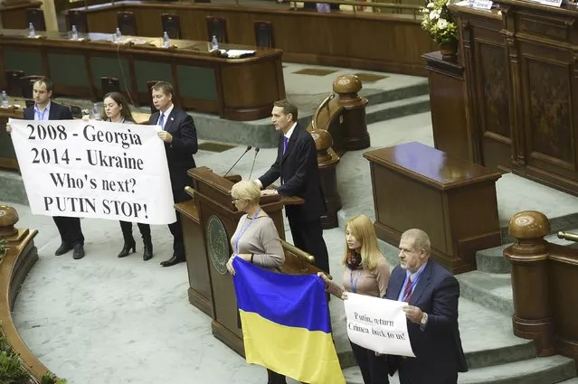 Ukrainian politicians hold banners reading "Putin, return Crimea back to us" and "2008 - Georgia, 2014 - Ukraine, Who is next? PUTIN STOP!" as they stage a protest during the Russian State Duma lower house of parliament speaker Sergei Naryshkin's speech at the Parliamentary Assembly of the Black Sea Economic Cooperation, in Bucharest, Romania, November 27, 2015. (Photo by Reuters/Inquam Photos)