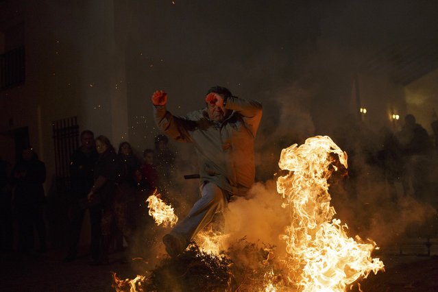 A man jumps over a bonfire during the “Luminarias” annual religious celebration on the eve of Saint Anthony's Day in the village of Alosno, southwest Spain, January 16, 2015. (Photo by Marcelo del Pozo/Reuters)