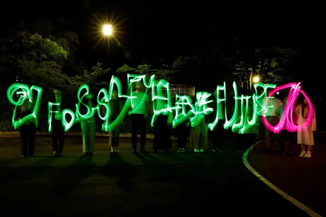 People create light sculptures with luminous pen lights conveying messages of peace and environmental protection during an event organised by Greenpeace on the day of the G7 summit in Hiroshima, western Japan on May 19, 2023. (Photo by Androniki Christodoulou/Reuters)
