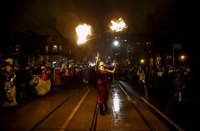 A performer throws a baton with fire on it in the air at the 26th Annual Kensington Market Winter Solstice Parade in Toronto, December 21, 2015. (Photo by Mark Blinch/Reuters)